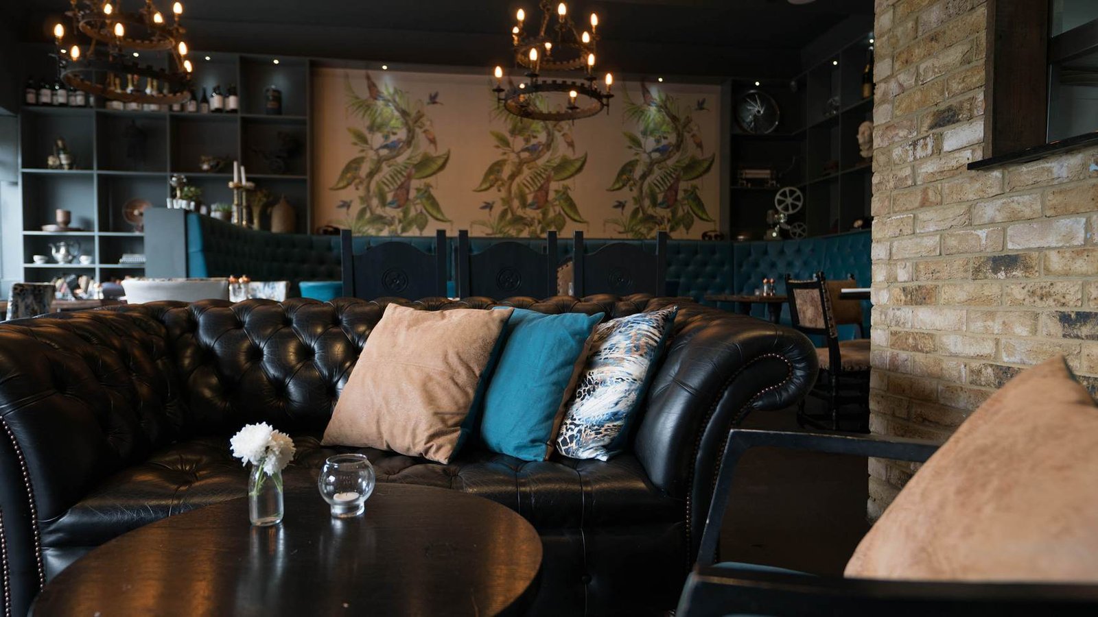 The lounge at Park's Edge Bar & Kitchen, with chesterfield seating, botanical mural and brass chandeliers