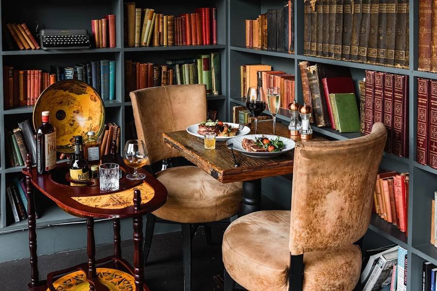 An intimate table for two set among the bookshelves at Park's Edge